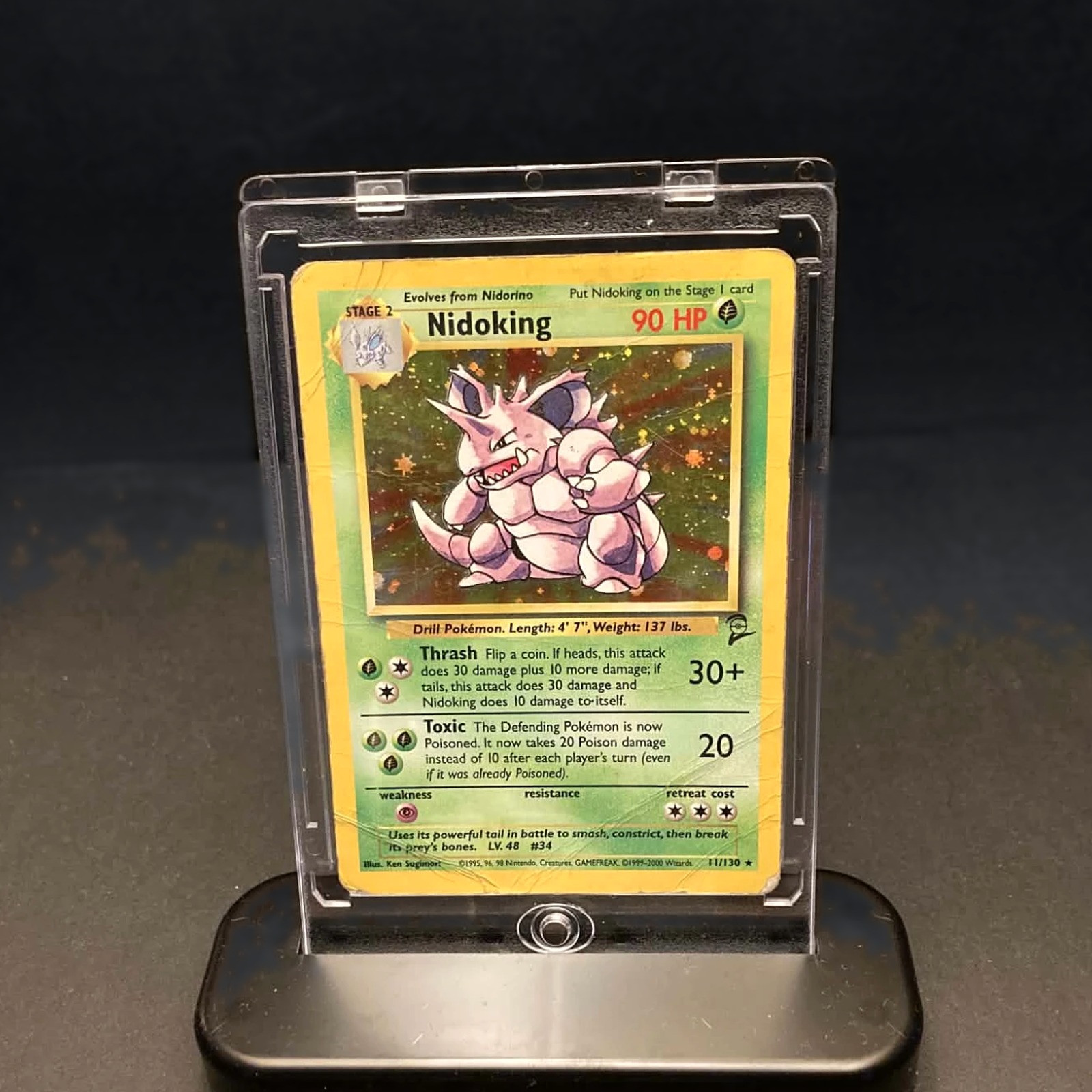 A Pok&eacute;mon card in a clear magnetic case on its black stand